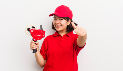 pretty hispanic girl feeling proud,smiling positively with thumbs up. packer concept