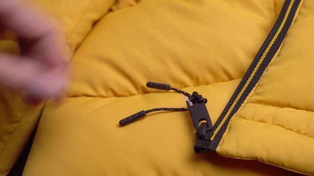 The girl's hands remove the price tag from the yellow jacket with scissors. A woman after shopping. A new thing. Buying clothes.