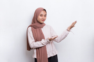 Happy young asian muslim woman pointing with fingers to different directions isolated on white background
 - obrazy, fototapety, plakaty