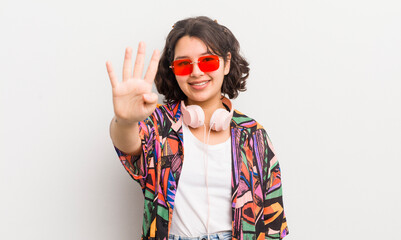 pretty hispanic girl smiling and looking friendly, showing number four. teenager concept