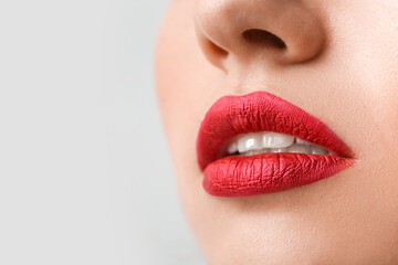 Obraz premium Beautiful woman with red lipstick on light background, closeup