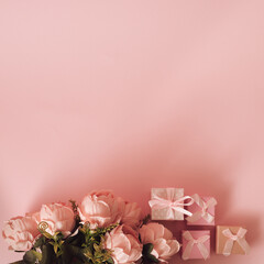 Top view flower bouquet and presents or gifts of love on minimal pastel pink background