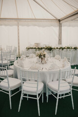 Table setting at a luxury event and beautiful flowers on the table. Beautiful wedding arch of flowers.