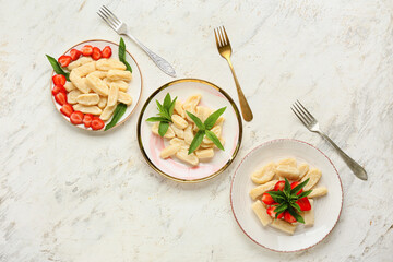 Plates with tasty lazy dumplings and forks on light background