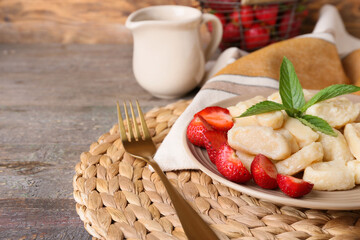 Plate of delicious lazy dumplings and strawberry on wooden table, closeup