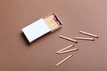 Box with wooden matchsticks on color background