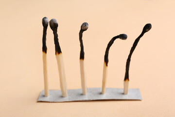 Burnt matches on beige background. Concept of emotional burnout