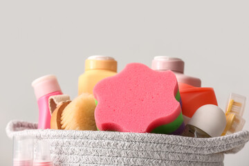Basket with different bath accessories and cosmetic products on light background, closeup