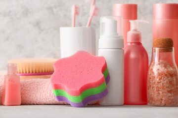 Set of different cosmetic products and bath accessories on light background, closeup