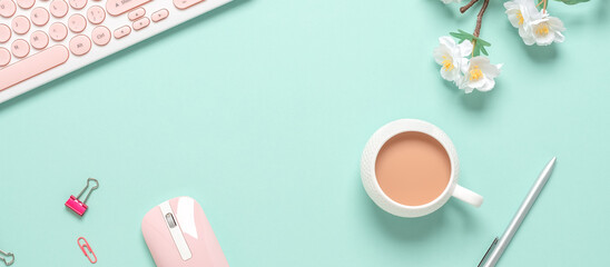 Top view office desk. Women's workspace of a blogger or freelancer. Keyboard, coffee cup and stationery on green pastel background. Spring stationery still life. Banner