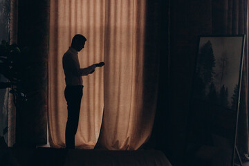 Morning of a stylish groom, man, in a black suit and tie, his preparations at the hotel, in a photo...