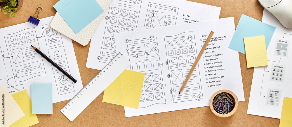 Wall mural web design concept banner. user experience designer desk with numerous website wireframe sketches an