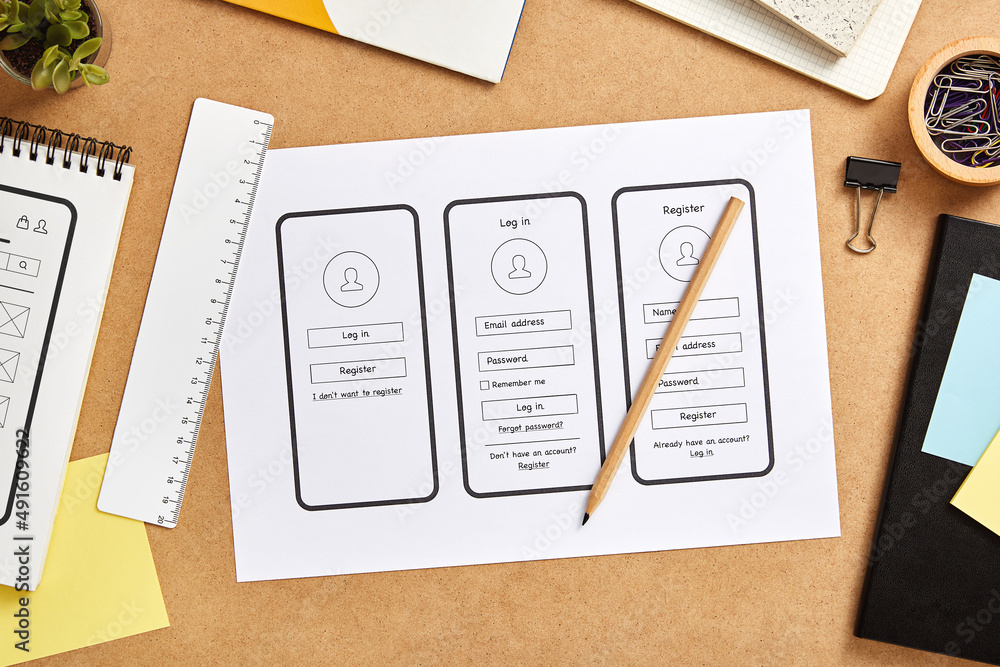 Wall mural ux design concept. mobile app wireframe sketches over product designer desk. top view.