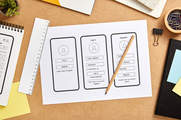 UX design concept. Mobile app wireframe sketches over product designer desk. Top view.