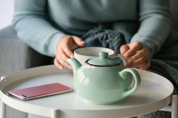 Fototapeta na wymiar Woman with cup of tasty blue tea at table, closeup