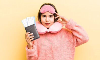 pretty hispanic girl feeling confused and puzzled, showing you are insane. flight passenger concept