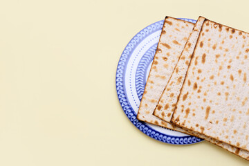 Plate with Jewish flatbread matza for Passover on yellow background
