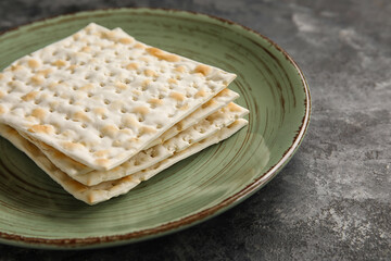 Plate with Jewish flatbread for Passover on dark background