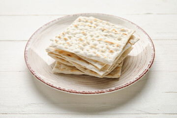 Plate with Jewish flatbread for Passover on white wooden background
