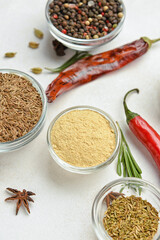 Glass bowls of aromatic spices on light background, closeup