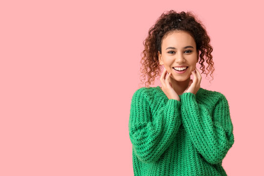 Young African-American Woman In Green Sweater On Pink Background