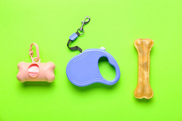 Pet waste bags, leash and chew bone on green background