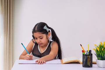Pretty little girl doing homework at home