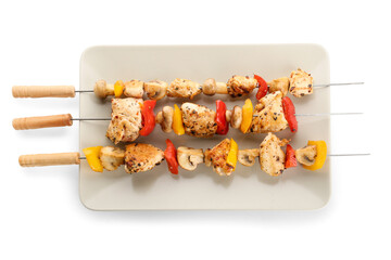 Plate of grilled chicken skewers with vegetables isolated on white background