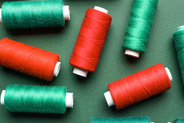 Different sewing threads on green background