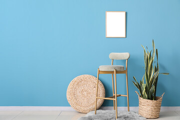 Stylish chair, blank poster and houseplant near blue wall