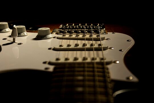 Guitar.Guitar's chords.Electric guitar.Music.Music background.Image of an electric guitar in the dark.Playing music with some friends in the dark.Rock and metal music.Guitar closeup