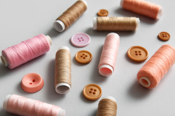 Thread spools and buttons on light background