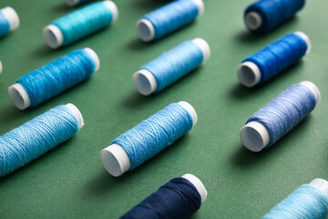 Thread spools on green background, closeup