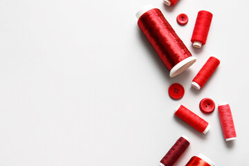 Thread spools and buttons on white background