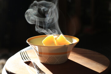 Boiled hot potatoes in a bowl on a wooden table