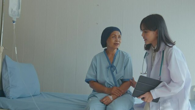 Cancer patient woman wearing head scarf after chemotherapy consulting and visiting doctor in hospital...