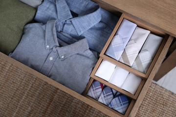 Open drawer with folded handkerchiefs and clothes indoors, top view - obrazy, fototapety, plakaty