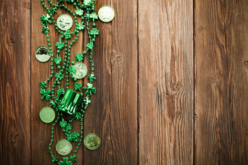 St Patricks Day border of shamrocks beads and coins over a rustic wood background