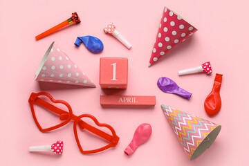 Calendar with date of April Fools Day and party decor on pink background