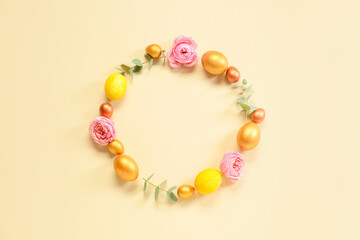 Frame made of Easter eggs and flowers on beige background