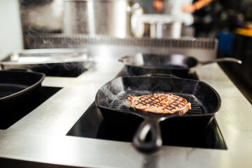 Cooking beef steak on a grilling pan in the kitchen