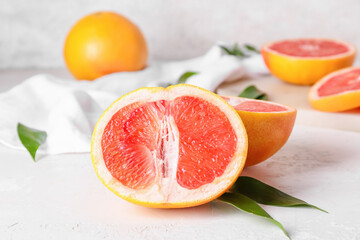 Tasty cut grapefruit on light background