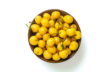 sweet yellow organic berries of cherry in wooden cup and scattered around isolated on white background Top view Flat lay Summer harvest concept