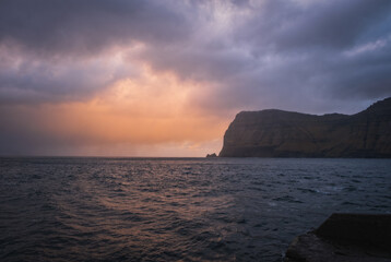 Mikladalur, Kalsoy, an island in the north-east of the Faroe Islands. Ocean and mountain at sunrise time. November 2021