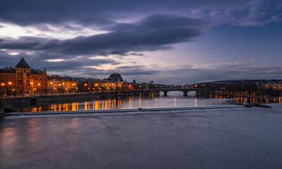 Obraz premium Dreamy night view of Vltava river with magical sky and lights from streets on early morning from the Charles Bridge in the Old Town of amazing historic city Prague, Czech Republic, Europe.