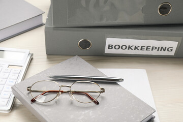 Bookkeeper's workplace with folders, glasses and stationery on wooden table
