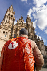 Camino de Santiago to Compostela with pilgrim in Obradoiro square looking the cathedral after finishing the way  in  Galicia, Spain , focus in foreground