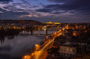 Fototapeta na wymiar Dreamy night view of Vltava river with magical sky and lights from streets and bridges on sundown behind the Prague Castle in the Old Town of amazing historic city Prague, Czech Republic, Europe.