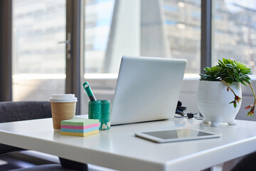 A desk in a city office without any people, with the skyscraper background
