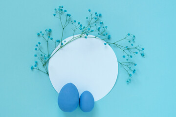 Flat lay mockup with blue eggs and small twigs of blooming flowers placed on empty white circle 